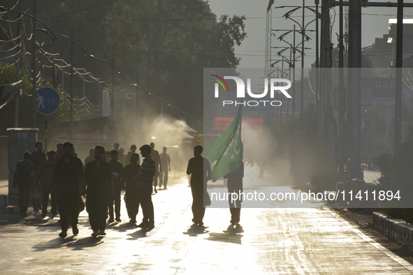 Kashmiri Shia Muslims are carrying a flag during a procession on the 8th of Muharram in Srinagar, Indian Administered Kashmir, on July 15, 2...