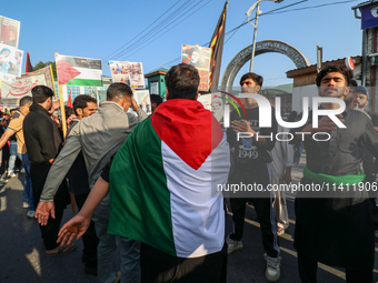 A Kashmiri Shia Muslim man is displaying a Palestinian flag during a procession on the 8th of Muharram in Srinagar, Indian Administered Kash...