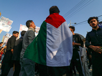 A Kashmiri Shia Muslim man is displaying a Palestinian flag during a procession on the 8th of Muharram in Srinagar, Indian Administered Kash...