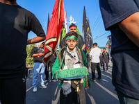 A Kashmiri Shia Muslim boy is walking in a procession on the 8th of Muharram in Srinagar, Indian Administered Kashmir, on July 15, 2024. (