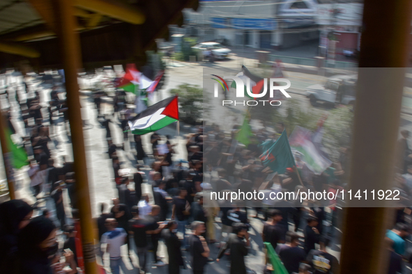 A Kashmiri Shia Muslim man is displaying a Palestinian flag during a procession on the 8th of Muharram in Srinagar, Indian Administered Kash...