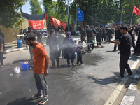 A Kashmiri Shia Muslim is spraying water on the people during a Muharram procession on the 8th of Muharram in Srinagar, Indian Administered...