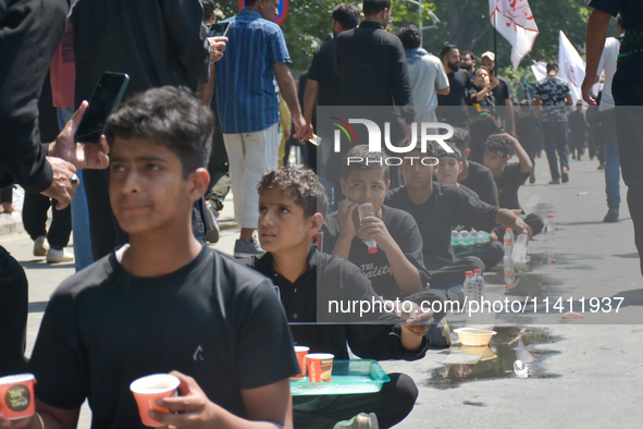 Kashmiri Shia Muslims are offering water during a Muharram procession on the 8th of Muharram in Srinagar, Indian Administered Kashmir, on Ju...