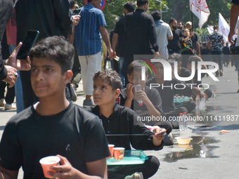 Kashmiri Shia Muslims are offering water during a Muharram procession on the 8th of Muharram in Srinagar, Indian Administered Kashmir, on Ju...