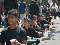 Kashmiri Shia Muslims are offering water during a Muharram procession on the 8th of Muharram in Srinagar, Indian Administered Kashmir, on Ju...