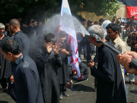 A Kashmiri Shia Muslim is spraying water on the people during a Muharram procession on the 8th of Muharram in Srinagar, Indian Administered...