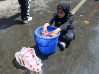 A Kashmiri Shia Muslim girl is offering water during a Muharram procession in Srinagar, Indian Administered Kashmir, on July 15, 2024. (