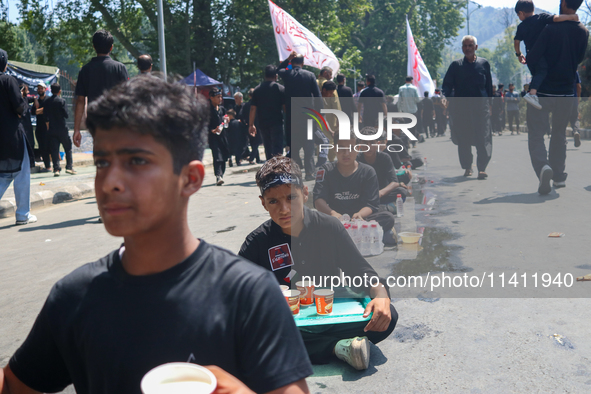 Kashmiri Shia Muslims are offering water during a Muharram procession on the 8th of Muharram in Srinagar, Indian Administered Kashmir, on Ju...