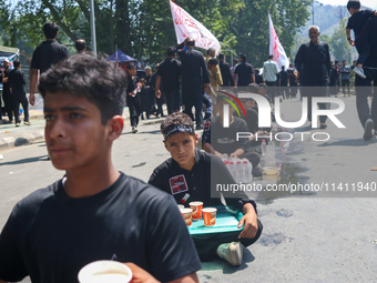 Kashmiri Shia Muslims are offering water during a Muharram procession on the 8th of Muharram in Srinagar, Indian Administered Kashmir, on Ju...