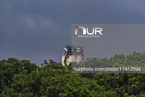 Students are standing on the roof to see the clash between BCL members (Ruling Party Members) and student protesters, during anti-quota prot...