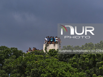 Students are standing on the roof to see the clash between BCL members (Ruling Party Members) and student protesters, during anti-quota prot...