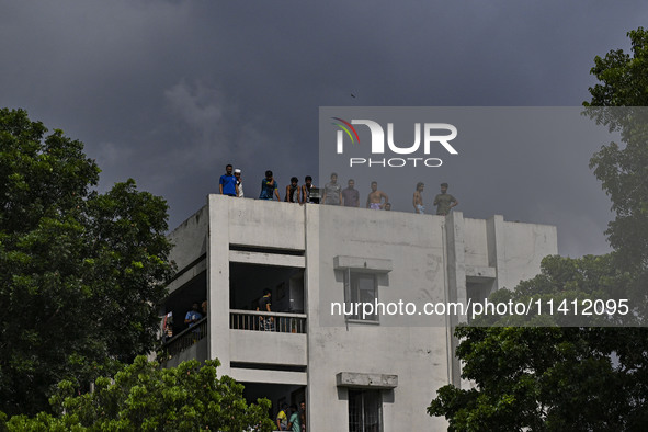 Students are standing on the roof to see the clash between BCL members (Ruling Party Members) and student protesters, during anti-quota prot...