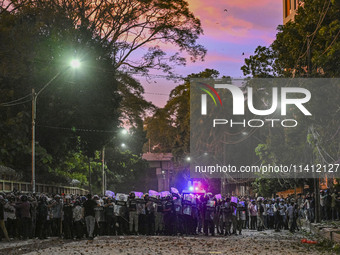 Bangladesh riot police are taking a position in front of Shahidullah Hall during clashes between anti-quota protesters and students backing...