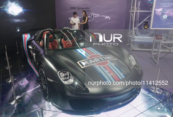 People are looking at Porsche's hybrid supercar ''918 Spyder'' at the West Lake in Hangzhou, China, on July 16, 2024. 