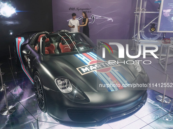 People are looking at Porsche's hybrid supercar ''918 Spyder'' at the West Lake in Hangzhou, China, on July 16, 2024. (