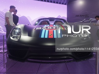 People are looking at Porsche's hybrid supercar ''918 Spyder'' at the West Lake in Hangzhou, China, on July 16, 2024. (