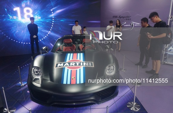 People are looking at Porsche's hybrid supercar ''918 Spyder'' at the West Lake in Hangzhou, China, on July 16, 2024. 