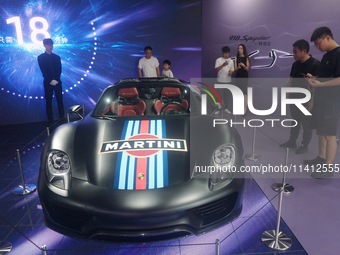 People are looking at Porsche's hybrid supercar ''918 Spyder'' at the West Lake in Hangzhou, China, on July 16, 2024. (