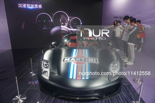 People are looking at Porsche's hybrid supercar ''918 Spyder'' at the West Lake in Hangzhou, China, on July 16, 2024. 