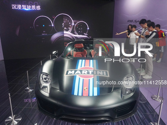 People are looking at Porsche's hybrid supercar ''918 Spyder'' at the West Lake in Hangzhou, China, on July 16, 2024. (