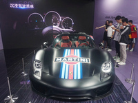 People are looking at Porsche's hybrid supercar ''918 Spyder'' at the West Lake in Hangzhou, China, on July 16, 2024. (