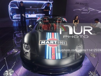 People are looking at Porsche's hybrid supercar ''918 Spyder'' at the West Lake in Hangzhou, China, on July 16, 2024. (