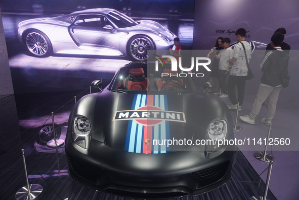 People are looking at Porsche's hybrid supercar ''918 Spyder'' at the West Lake in Hangzhou, China, on July 16, 2024. 