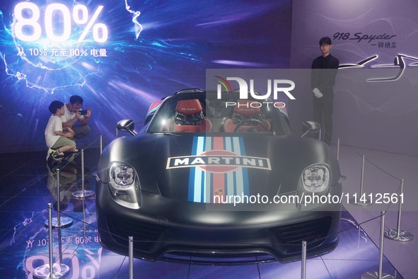 People are looking at Porsche's hybrid supercar ''918 Spyder'' at the West Lake in Hangzhou, China, on July 16, 2024. 