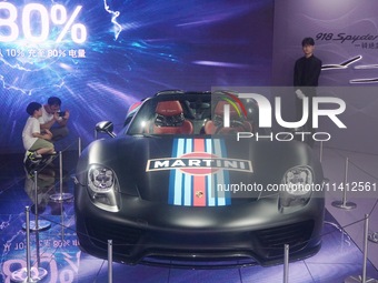 People are looking at Porsche's hybrid supercar ''918 Spyder'' at the West Lake in Hangzhou, China, on July 16, 2024. (