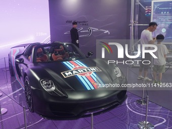 People are looking at Porsche's hybrid supercar ''918 Spyder'' at the West Lake in Hangzhou, China, on July 16, 2024. (