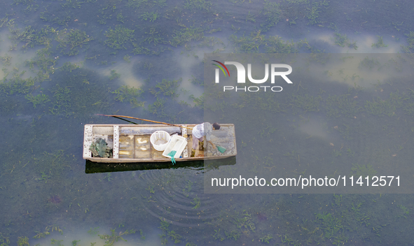 A crab farmer is performing daily management tasks such as increasing oxygen, fetching water, and feeding at a hairy crab ecological breedin...