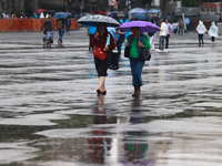 People are covering themselves from the rain with umbrellas while walking through downtown in Mexico City, Mexico, on July 10, 2024. (