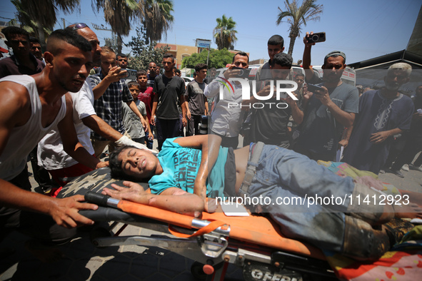 Injured Palestinians are being brought to Al-Aqsa Martyrs Hospital for medical treatment after the Israeli attacks in Deir al-Balah, Gaza, o...