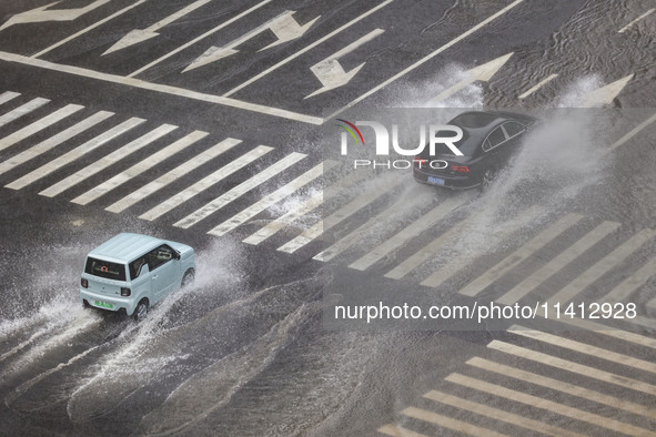 Vehicles are driving through heavy rain in the West Coast New Area of Qingdao, Shandong province, China, on July 16, 2024. 