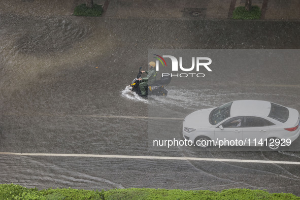 Vehicles are driving through heavy rain in the West Coast New Area of Qingdao, Shandong province, China, on July 16, 2024. 