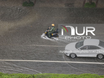 Vehicles are driving through heavy rain in the West Coast New Area of Qingdao, Shandong province, China, on July 16, 2024. (