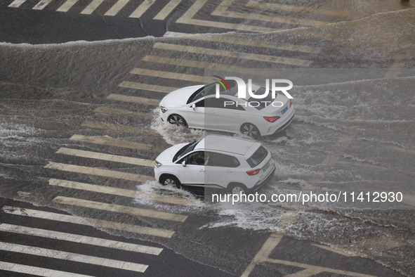 Vehicles are driving through heavy rain in the West Coast New Area of Qingdao, Shandong province, China, on July 16, 2024. 