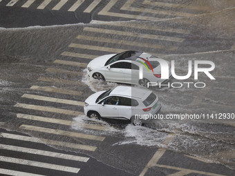 Vehicles are driving through heavy rain in the West Coast New Area of Qingdao, Shandong province, China, on July 16, 2024. (