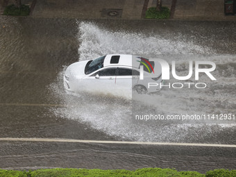 Vehicles are driving through heavy rain in the West Coast New Area of Qingdao, Shandong province, China, on July 16, 2024. (