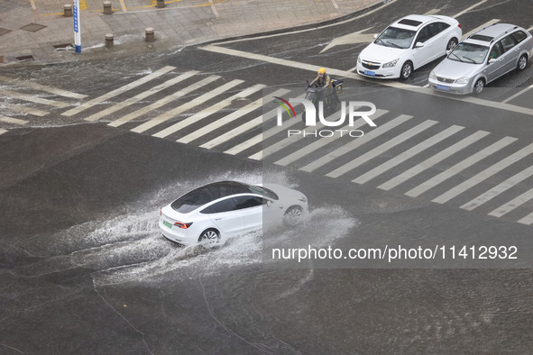 Vehicles are driving through heavy rain in the West Coast New Area of Qingdao, Shandong province, China, on July 16, 2024. 