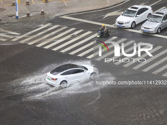 Vehicles are driving through heavy rain in the West Coast New Area of Qingdao, Shandong province, China, on July 16, 2024. (