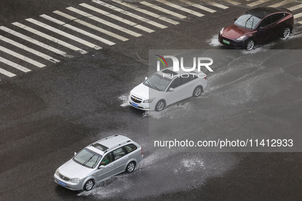 Vehicles are driving through heavy rain in the West Coast New Area of Qingdao, Shandong province, China, on July 16, 2024. 