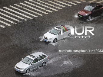 Vehicles are driving through heavy rain in the West Coast New Area of Qingdao, Shandong province, China, on July 16, 2024. (