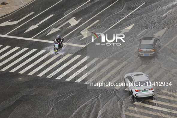 Vehicles are driving through heavy rain in the West Coast New Area of Qingdao, Shandong province, China, on July 16, 2024. 