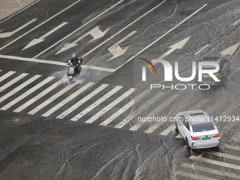 Vehicles are driving through heavy rain in the West Coast New Area of Qingdao, Shandong province, China, on July 16, 2024. (