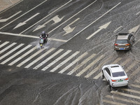 Vehicles are driving through heavy rain in the West Coast New Area of Qingdao, Shandong province, China, on July 16, 2024. (