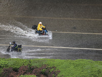 Citizens are riding during a rainstorm in the West Coast New Area of Qingdao, Shandong province, China, on July 16, 2024. (