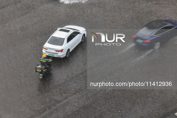 Vehicles are driving through heavy rain in the West Coast New Area of Qingdao, Shandong province, China, on July 16, 2024. 