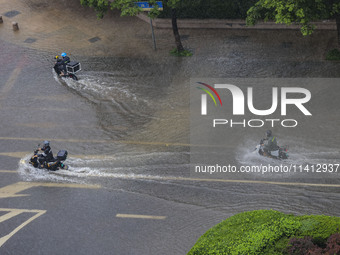 Citizens are riding during a rainstorm in the West Coast New Area of Qingdao, Shandong province, China, on July 16, 2024. (