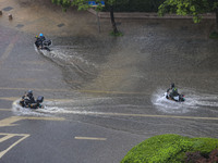 Citizens are riding during a rainstorm in the West Coast New Area of Qingdao, Shandong province, China, on July 16, 2024. (